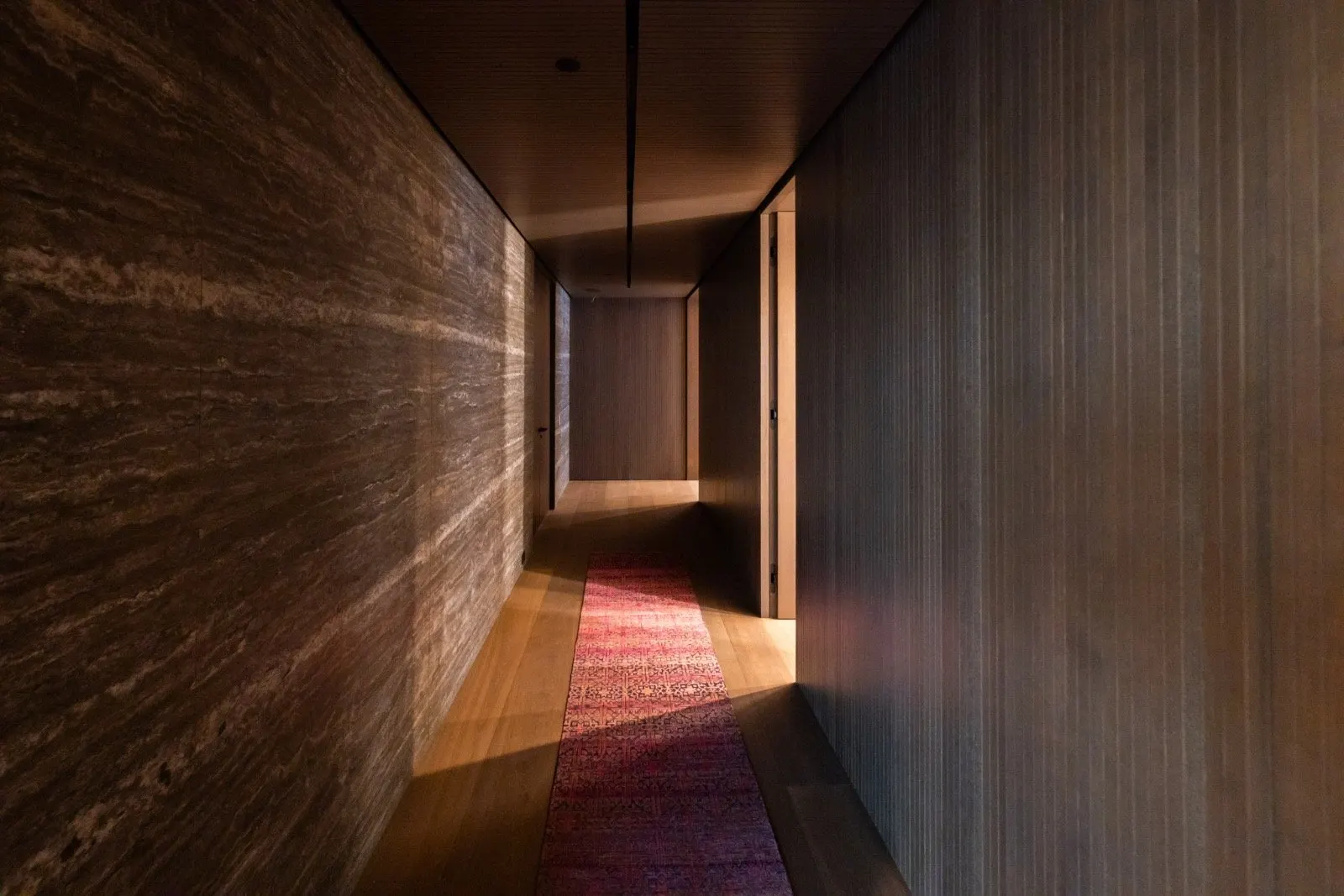 The Getty House — 684Firth Brentwood CA LA Interior Hallway Stone Accent Wall Wood Paneling Linear Lighting  Modern Home