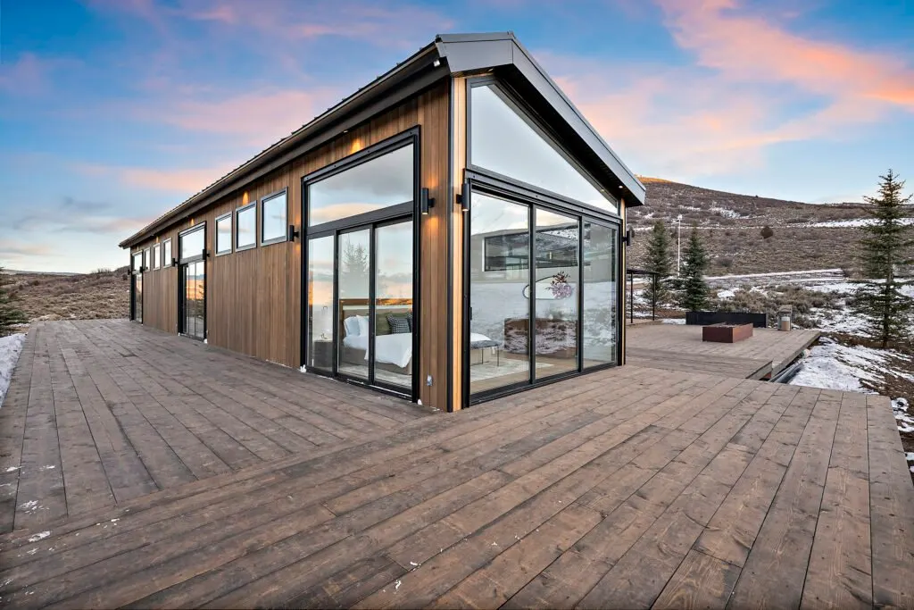 Icon Haus — glass walls and deck glowing at sunset