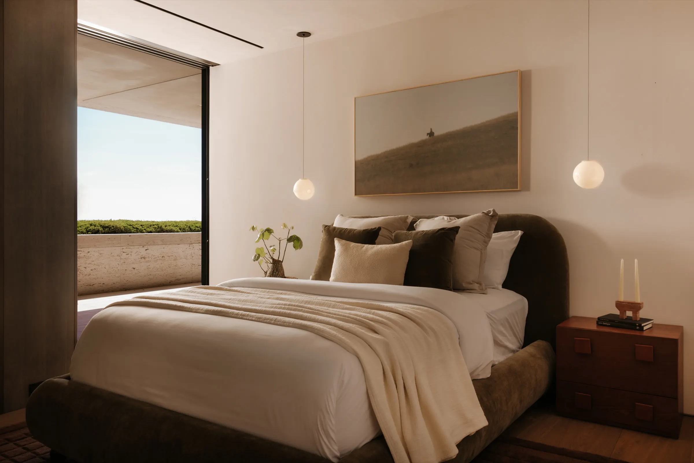 The Getty House, Brentwood — bedroom with arched headboard opening to a terrace
