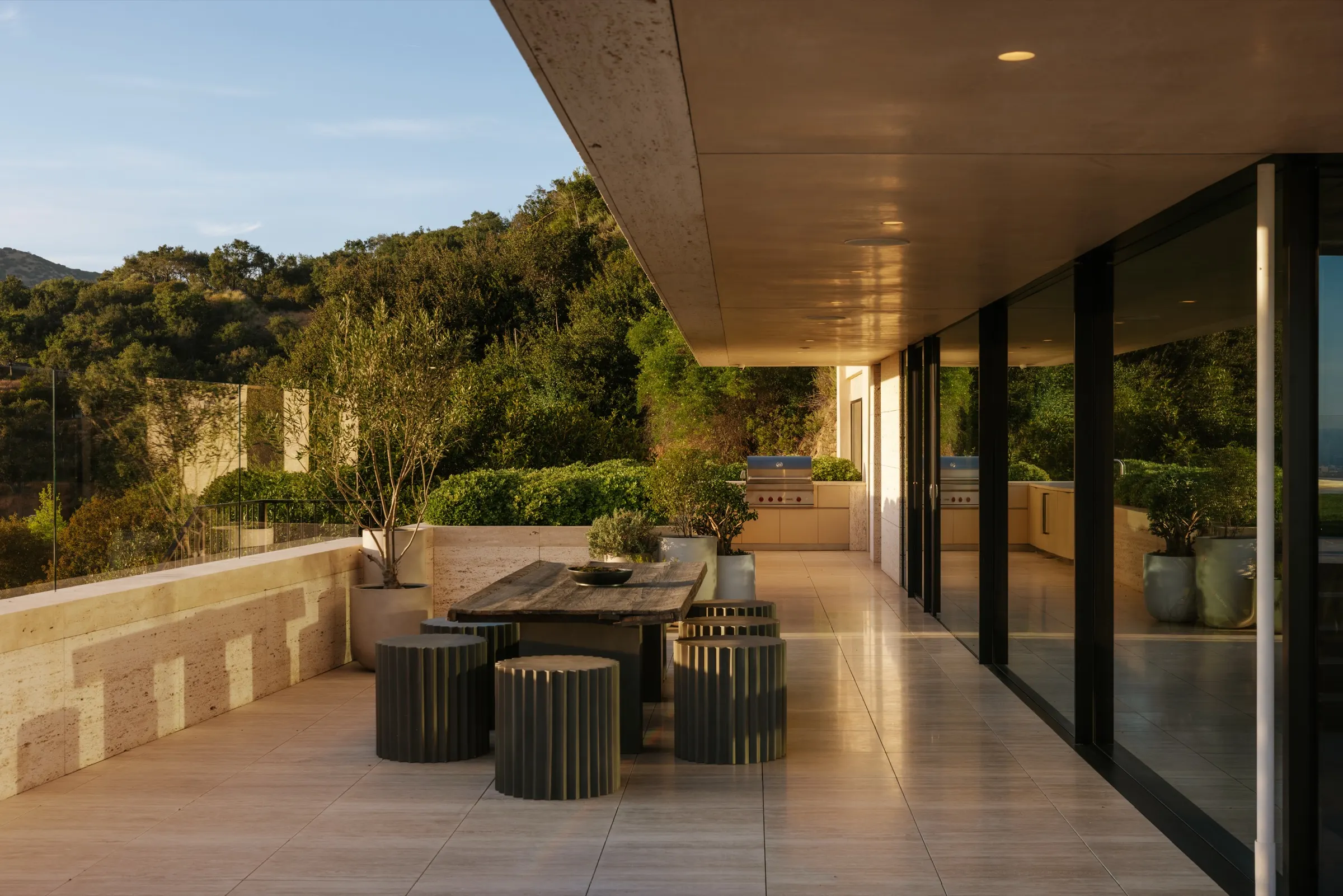 The Getty House, Brentwood — covered terrace with outdoor dining in travertine