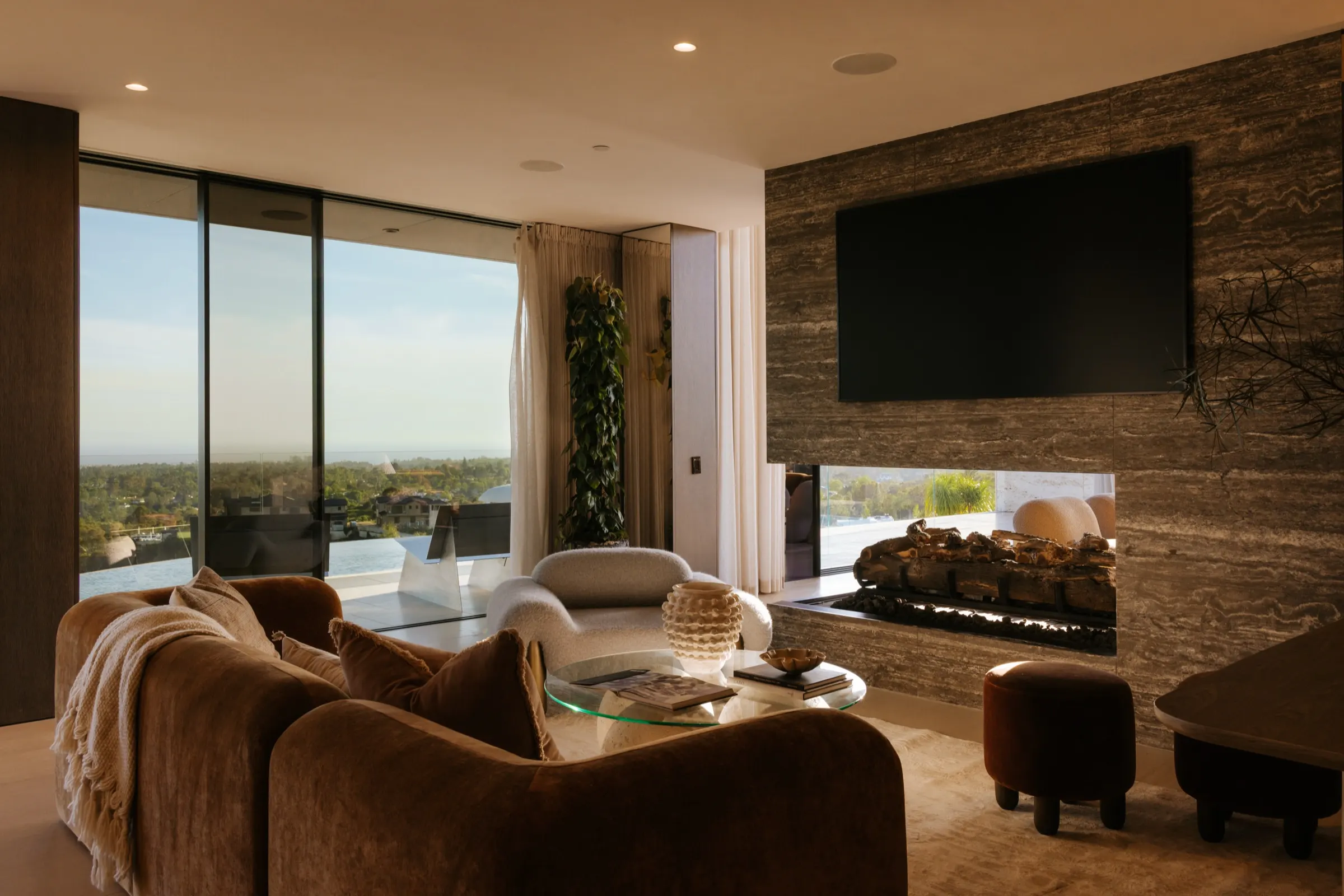 The Getty House, Brentwood — den with travertine fireplace wall