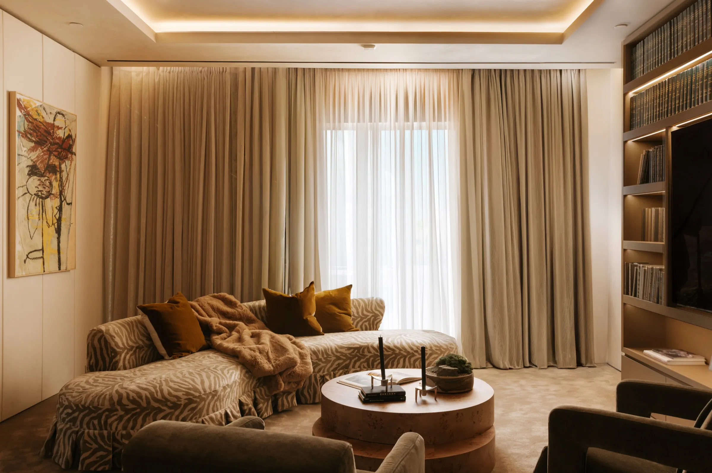 The Getty House, Brentwood — family lounge with linen drapes and backlit shelving