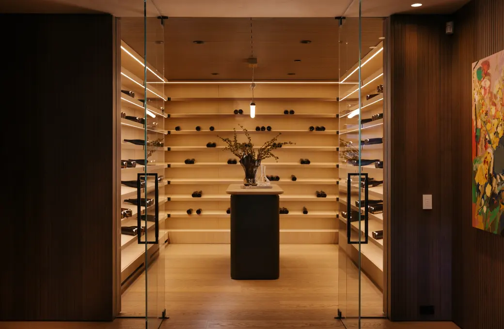 The Getty House wine cellar behind glass doors with backlit oak