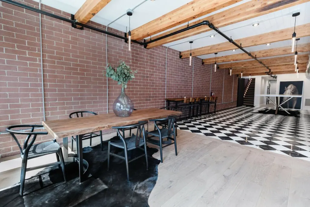 Main Street — dining space against the preserved brick wall under timber beams