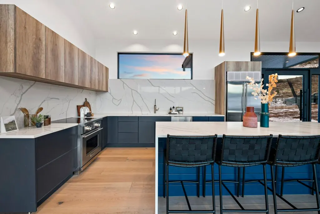 Icon Haus — kitchen detail: navy cabinetry, wood uppers, marble and quartz