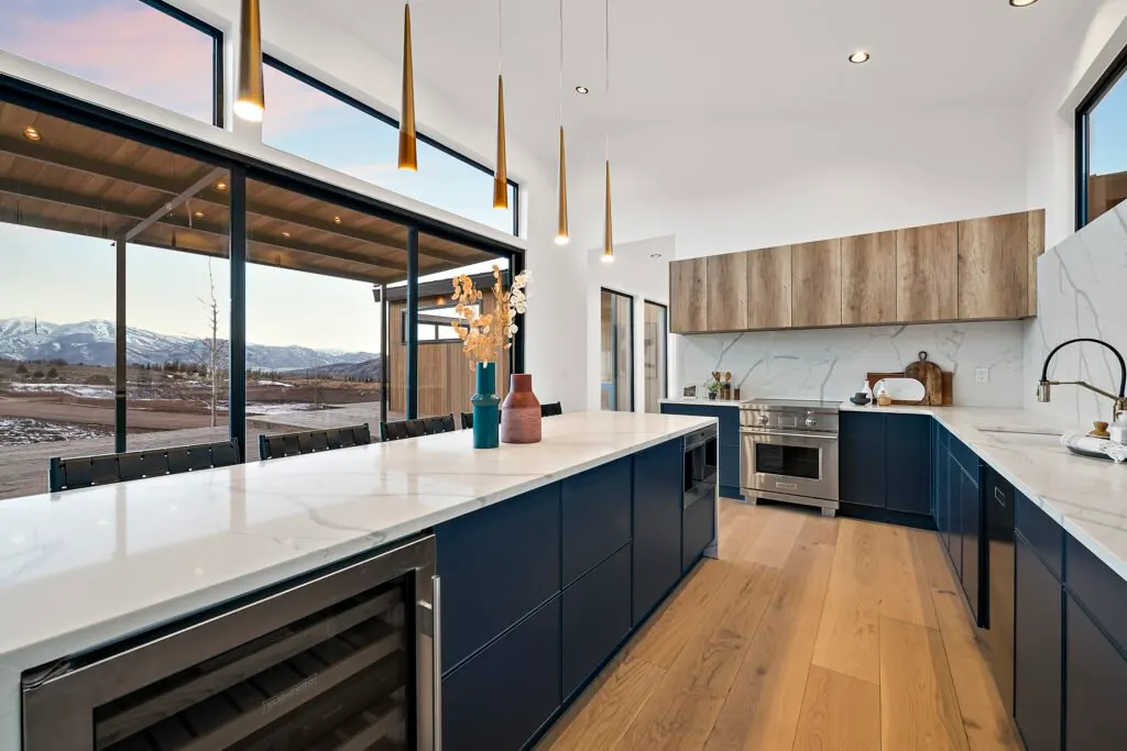 Icon Haus — navy island kitchen with wine fridge and mountain view