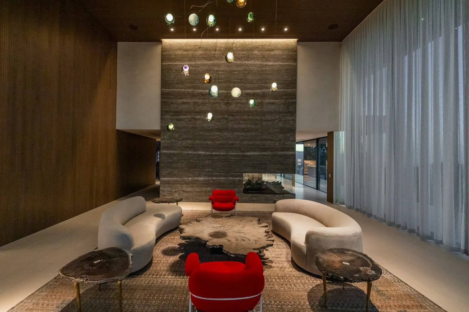 Getty House — lounge with two-sided fireplace and wood feature wall