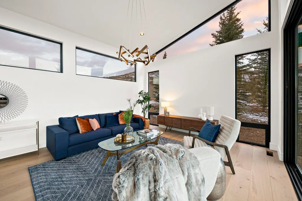 Icon Haus — living room vignette with navy sofa and wood credenza beneath sculptural lighting