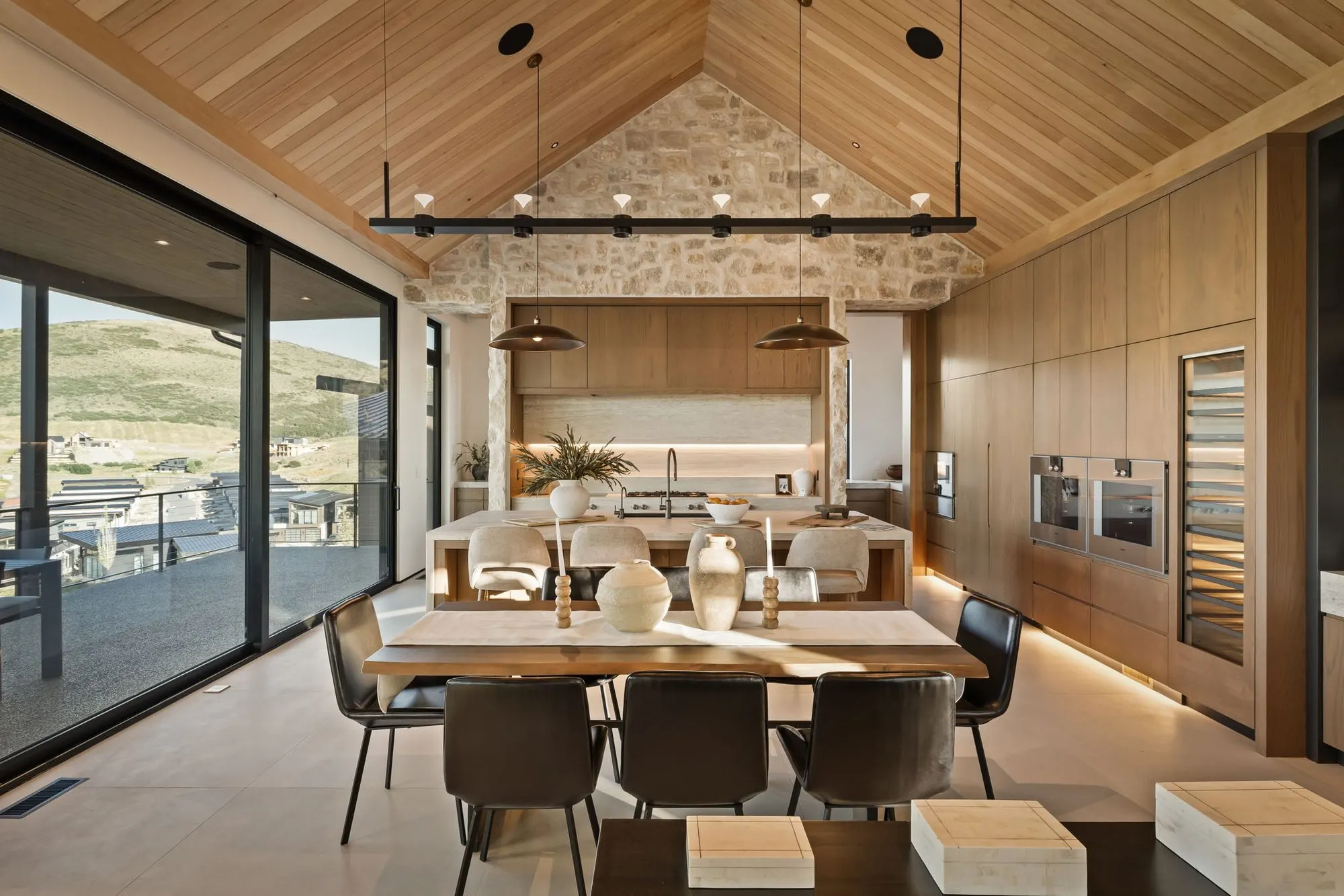 Lumen — dining under the vaulted cedar ceiling with a linear pendant