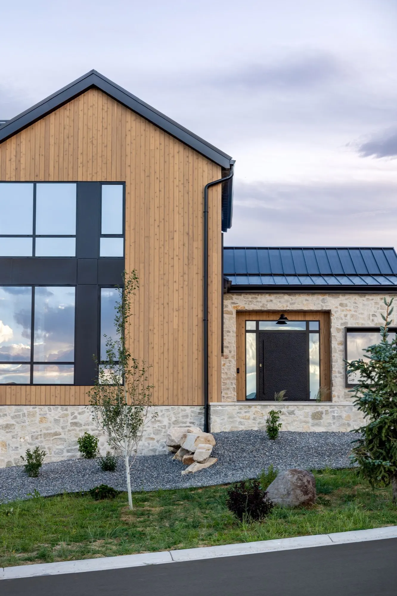 Lumen — glass gable and entry under an evening sky