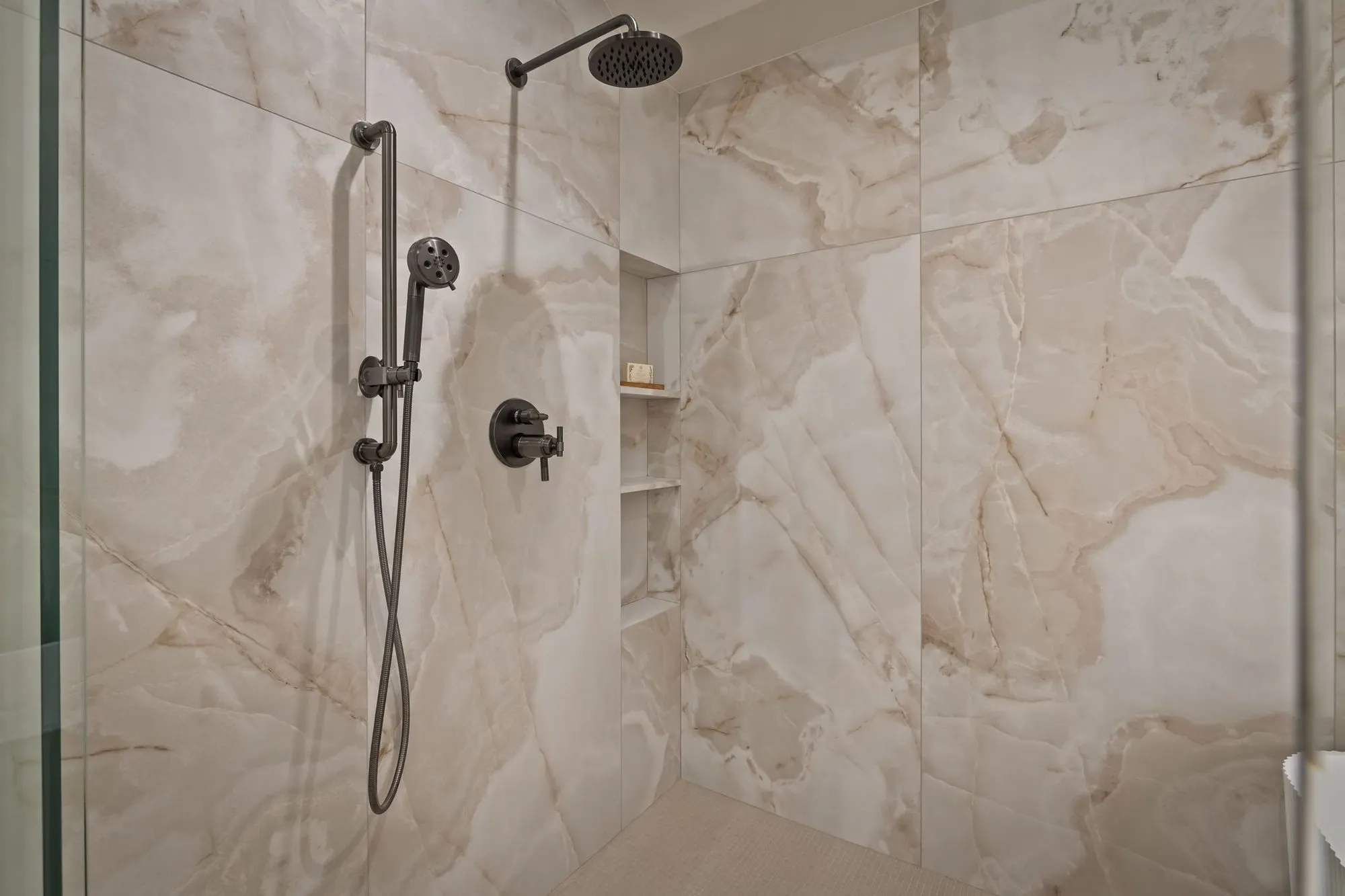 Lumen — walk-in shower clad in a book-matched stone slab