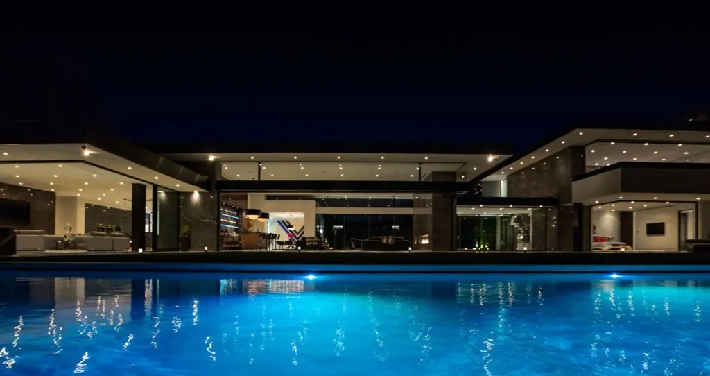 Stradella — primary suite wrapped in floor-to-ceiling glass overlooking Los Angeles