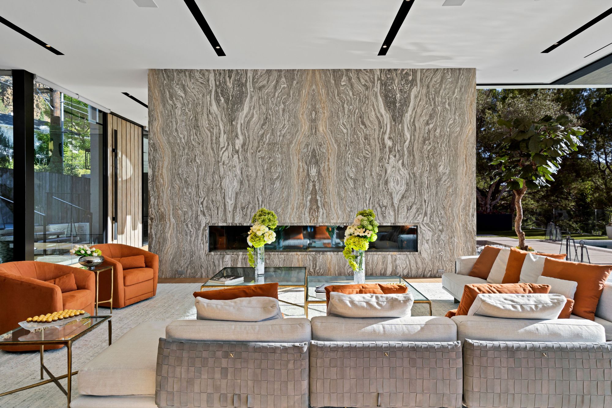 Flicker Estate — 13-foot living room anchored by the layered stone fireplace