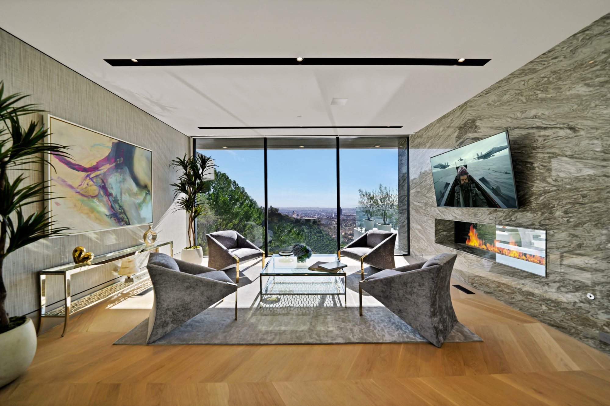 Flicker Estate — lounge with stone fireplace, glass pocketed open to the city