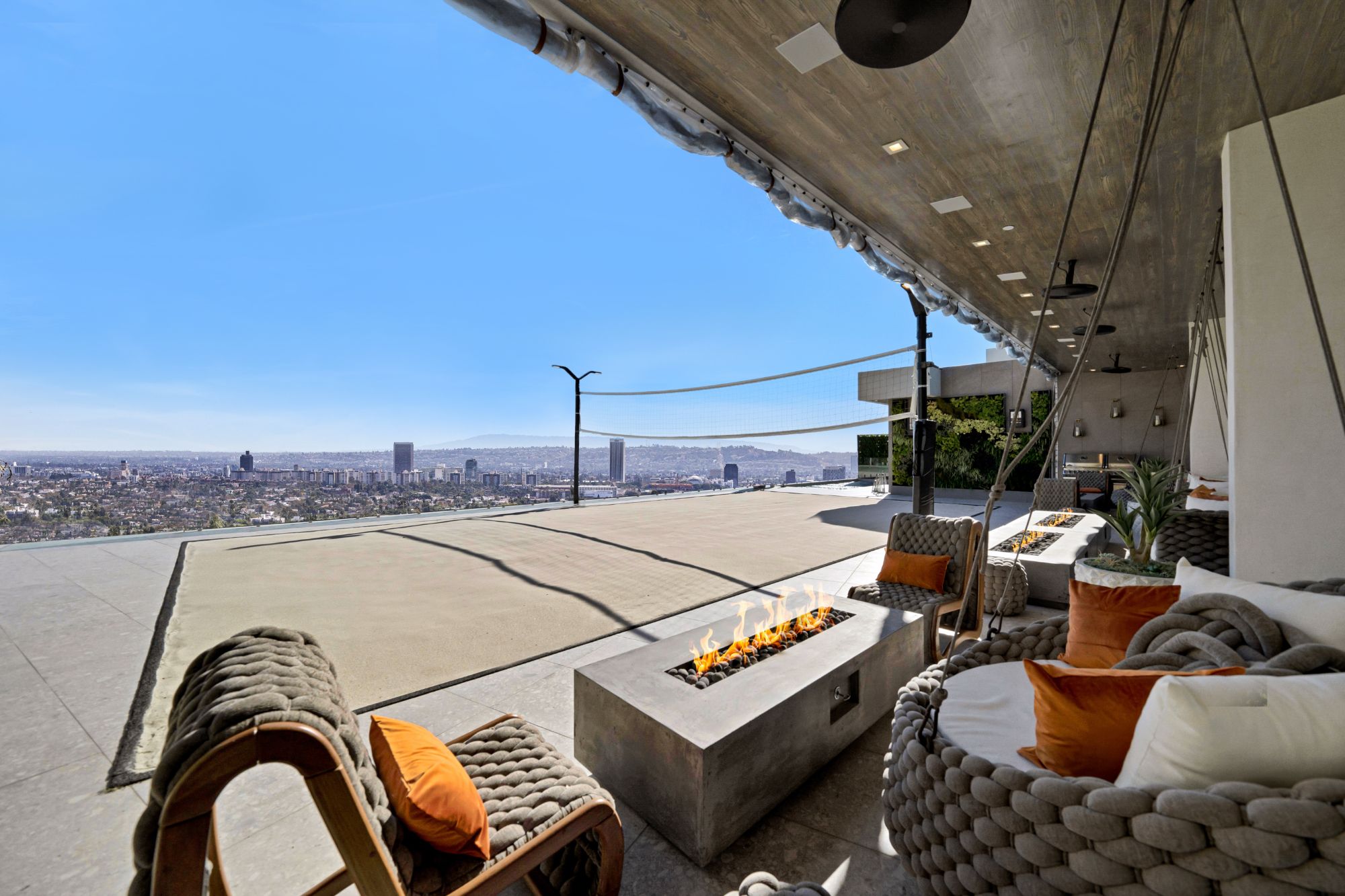 Flicker Estate — roof terrace — fire pit, sand volleyball court, and the skyline
