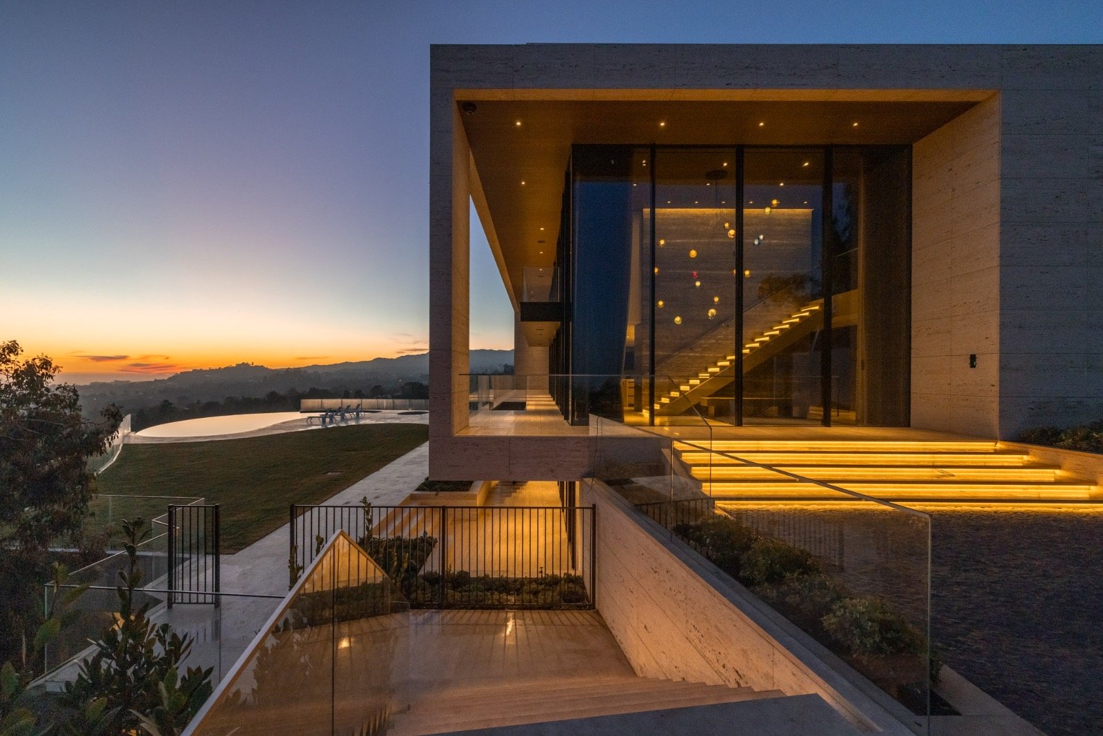 The Getty House — 684 Firth Brentwood CA LA Exterior Sunset Facade Travertine Illuminated Entry Stairs  Modern Home