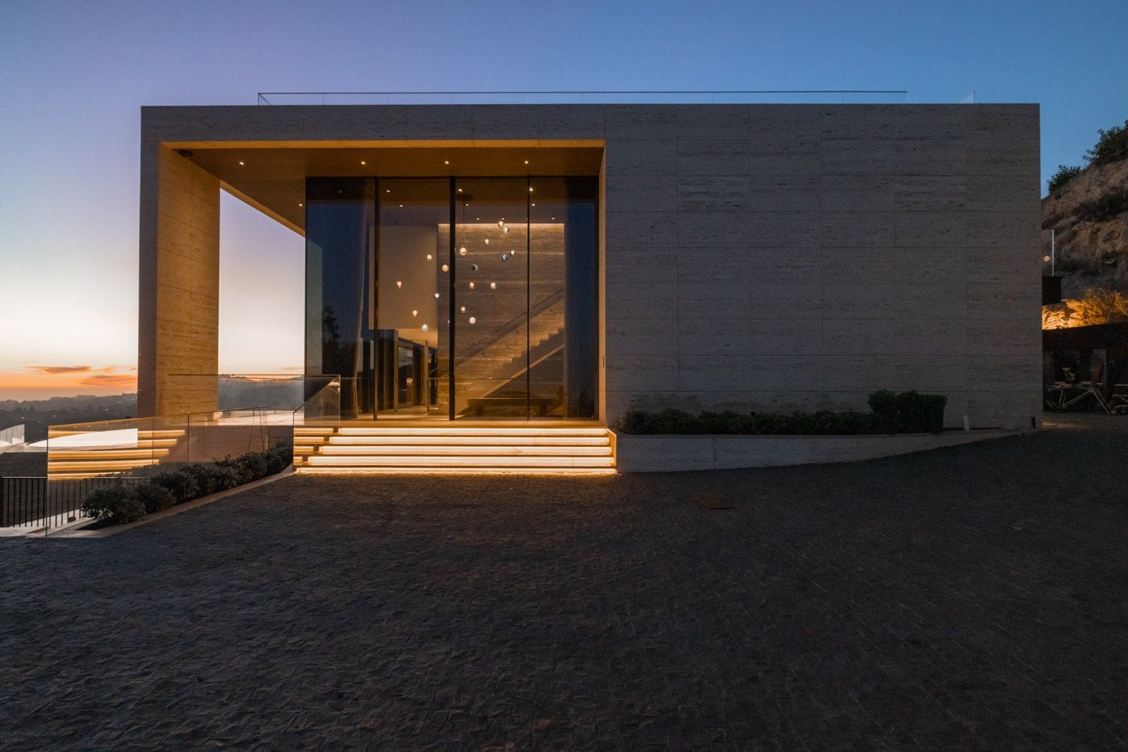 Getty House — travertine and glass façade at dusk, front entry