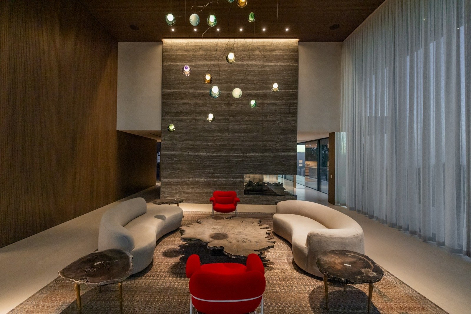 Getty House — lounge with two-sided fireplace and wood feature wall