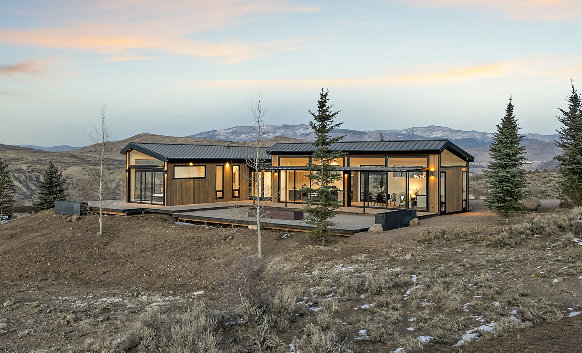 Icon Haus — wood siding and glass walls set against the mountain landscape