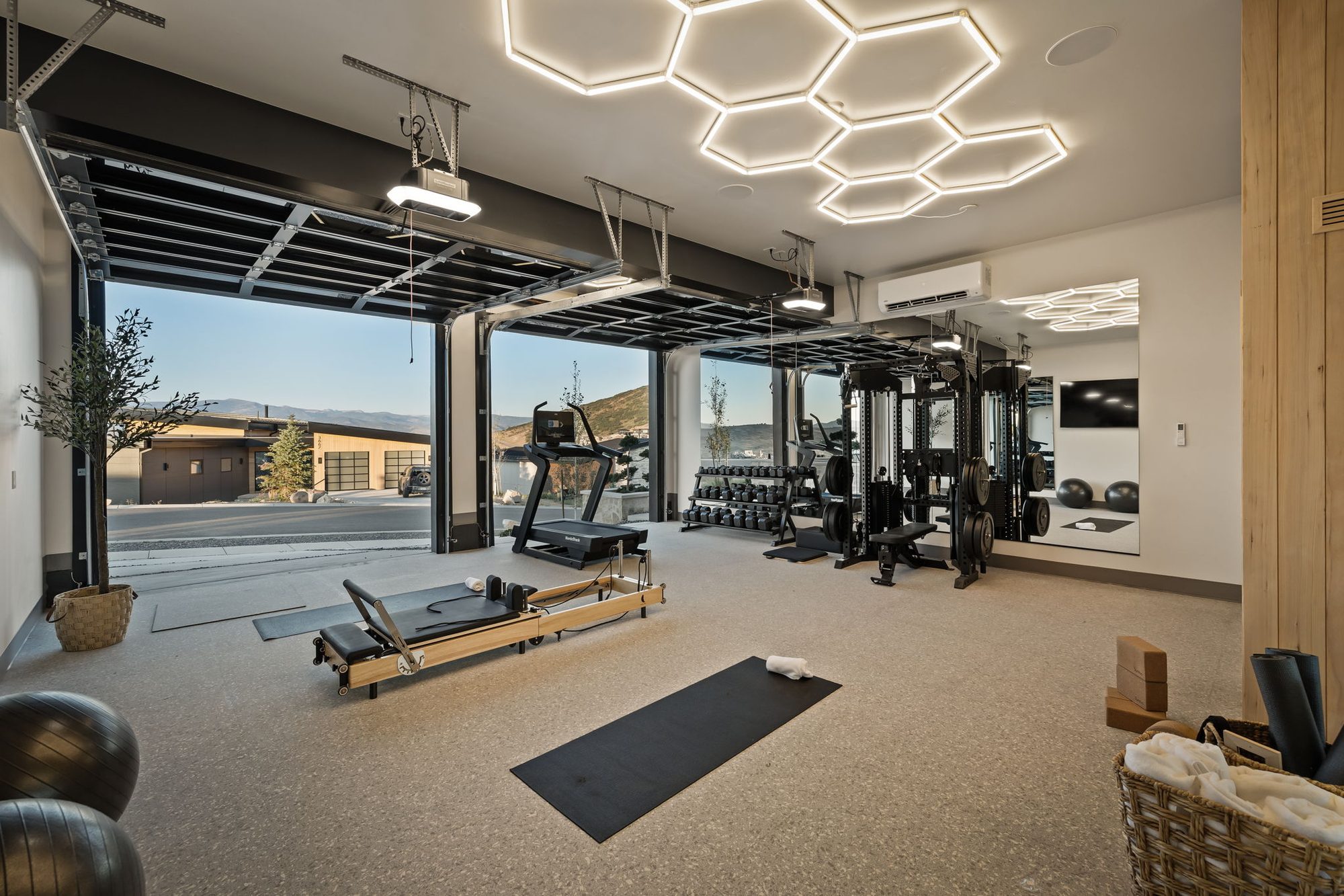 Lumen home gym with glass garage doors open to the hillside