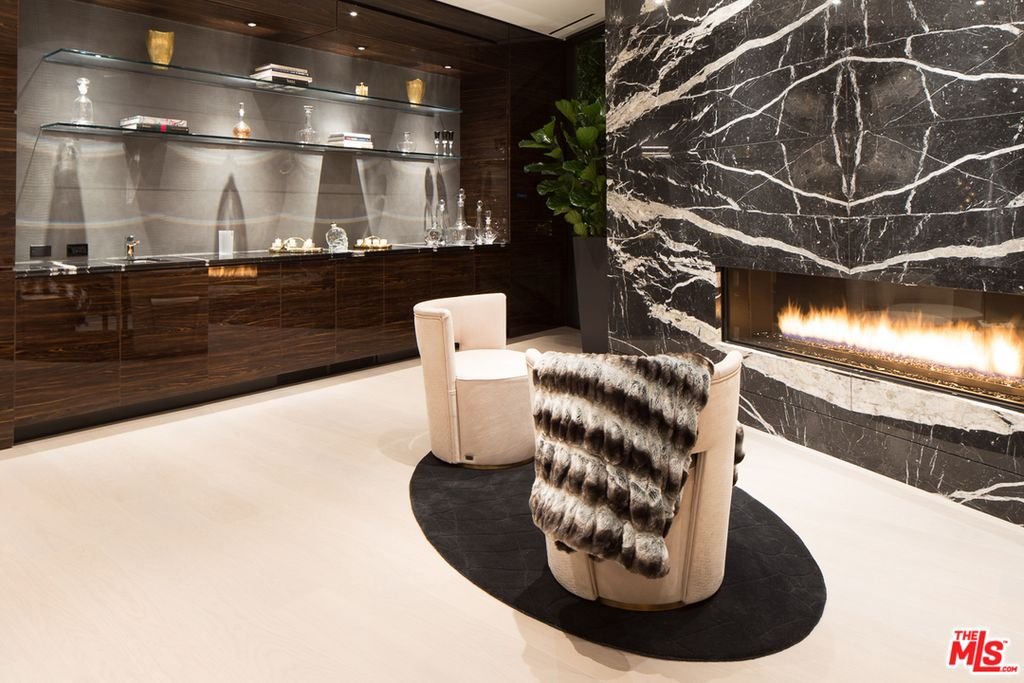 Thrasher Ave — bar lounge with marble fireplace and backlit glass shelving