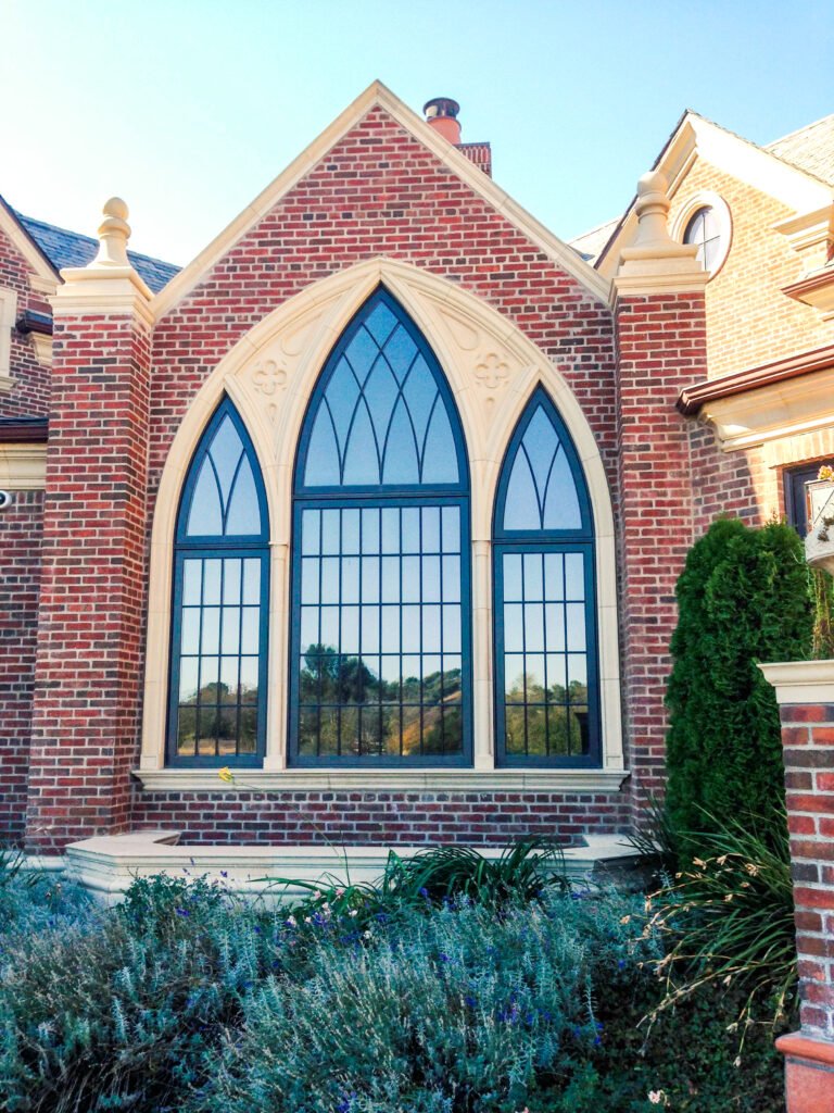 White Stallion — Gothic cathedral window detail set in brick masonry